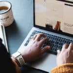 person using macbook pro on black table