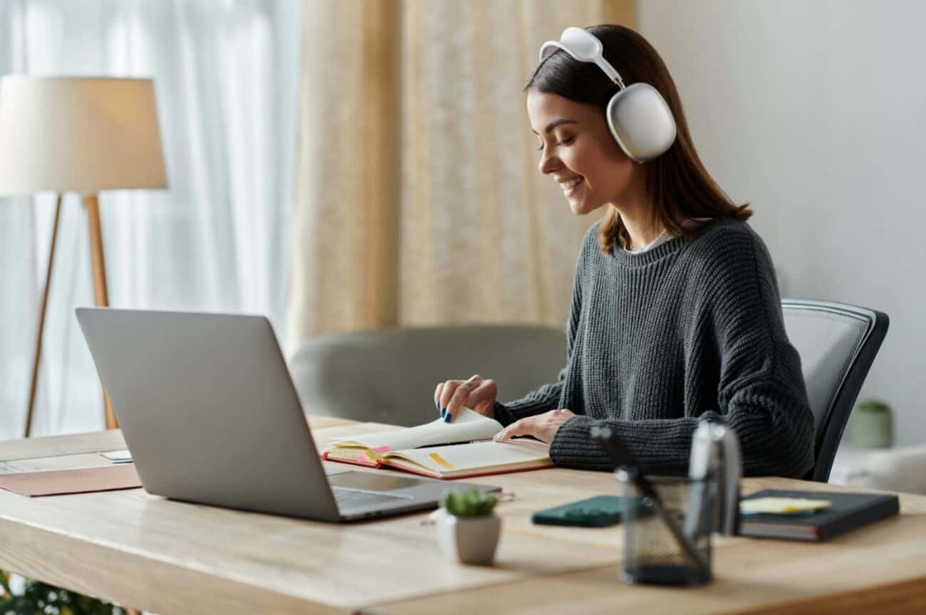 A young woman wearing headphones and creating content supported by AI tools; revising useful ideas before finalizing the copy